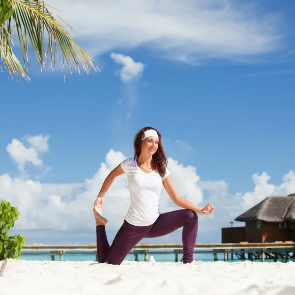 Güzel kadını kumsalda yoga egzersizleri yapıyor — Stok fotoğraf