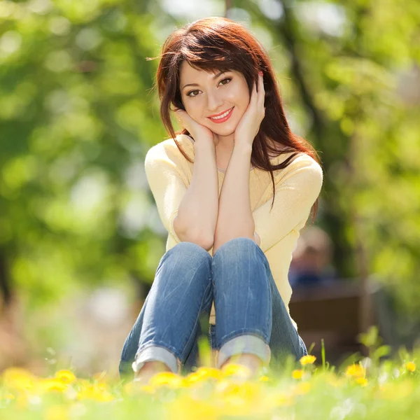 Молодая женщина в парке с цветами — стоковое фото