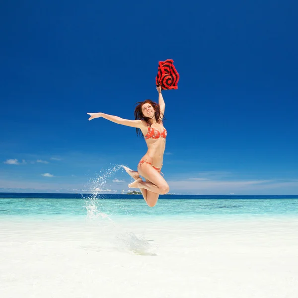 Joyeux jeune femme sautant sur la plage — Photo