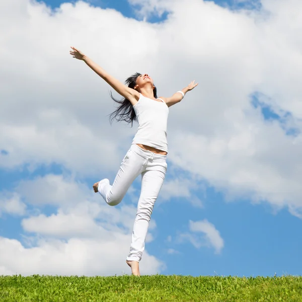 genç ve güzel kadın yeşil çimenlerin üzerinde atlama