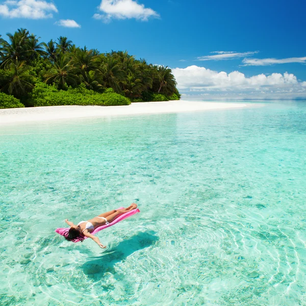 Mulher que relaxa no colchão inflável no mar Fotos De Bancos De Imagens