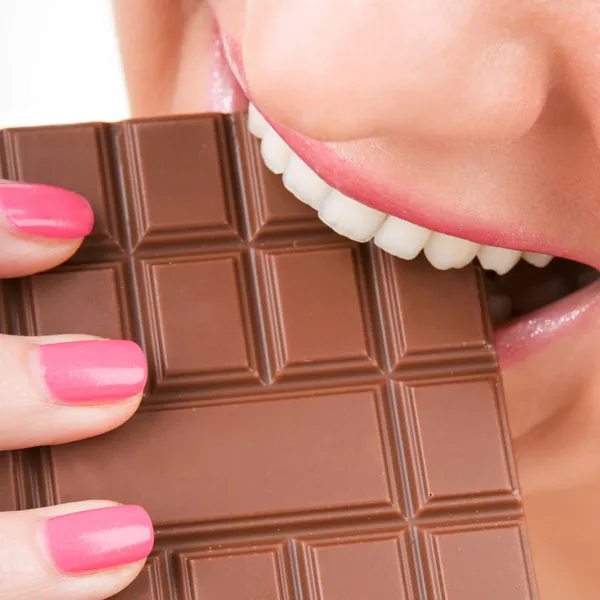 Веселая женщина ест шоколад — стоковое фото