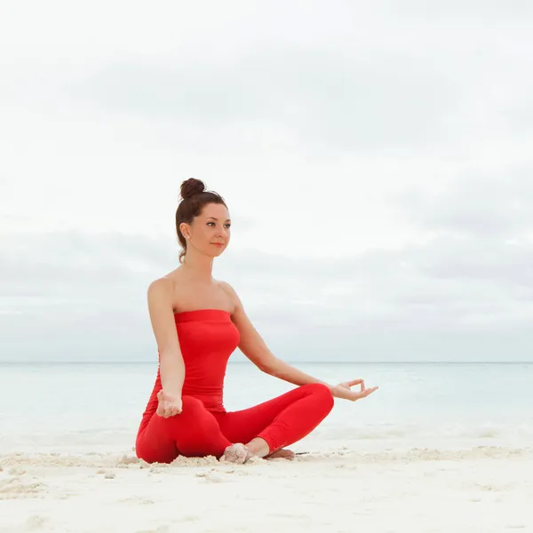 Pretty woman doing yoga exercises on the beach — Stock Photo, Image