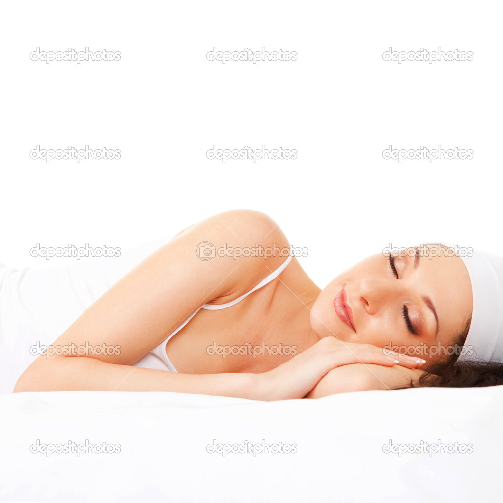 Cute woman sleeps on the white bed