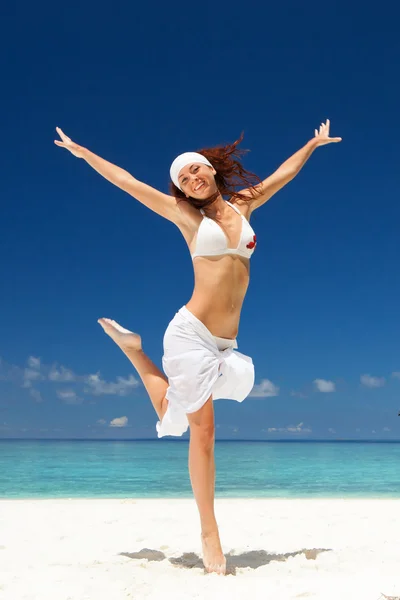 Gelukkig jonge vrouw springen op de tropisch strand — Stockfoto