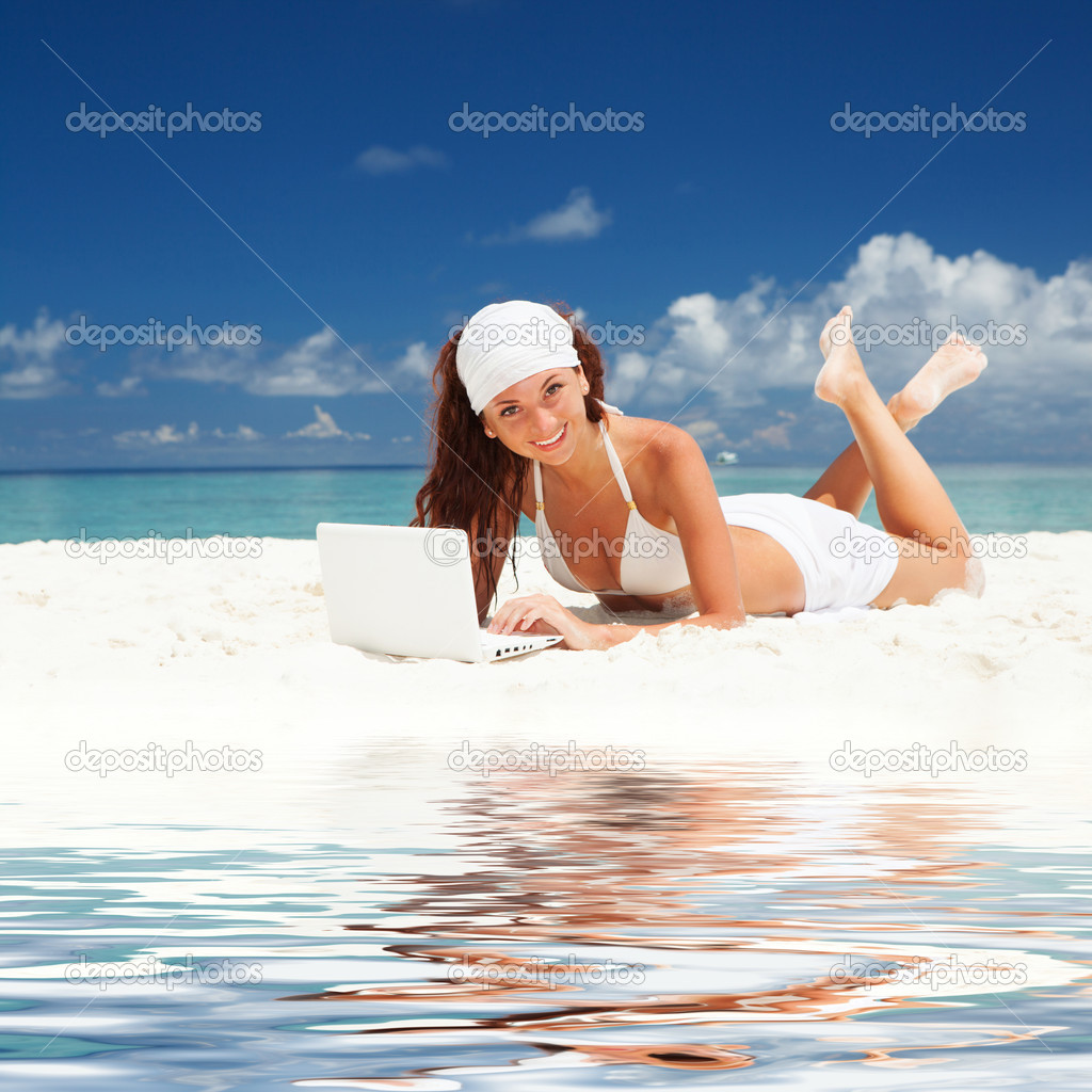 Cute woman with white laptop on the summer beach