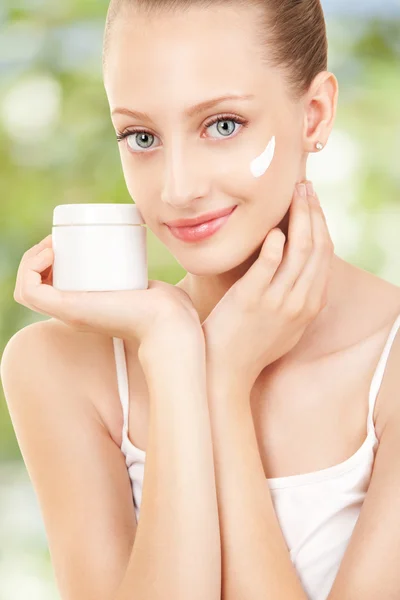 Carino donna applicando crema al suo viso — Foto Stock