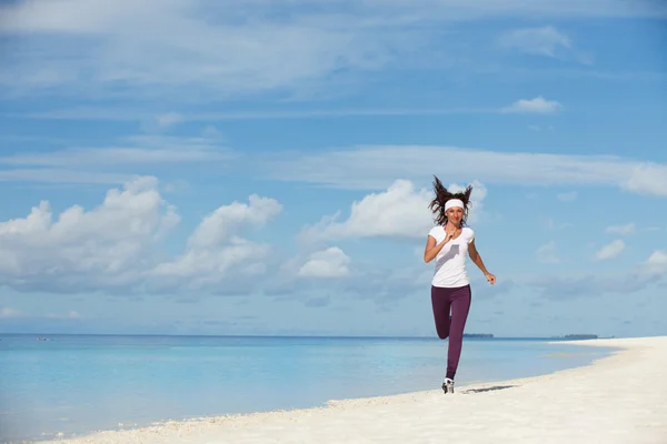 Jeune femme courant sur la plage — Photo