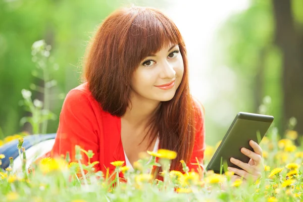 Mujer feliz con tableta en el parque — Foto de Stock