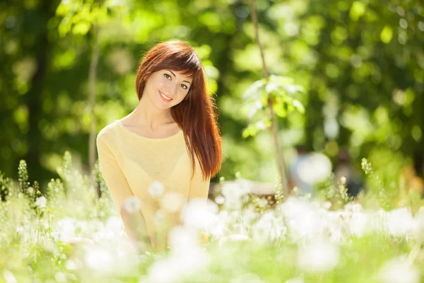 Parktaki çiçekli genç kadın. — Stok fotoğraf