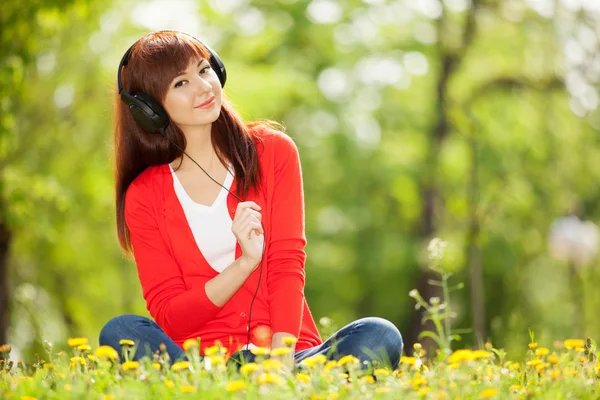 Donna felice con cuffie relax nel parco — Foto Stock