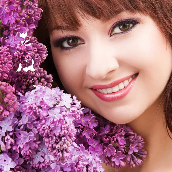 Junge Frau mit Blumen auf weißem Hintergrund — Stockfoto