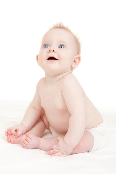 Симпатичный ребенок с красивыми голубыми глазами на белой кровати — стоковое фото