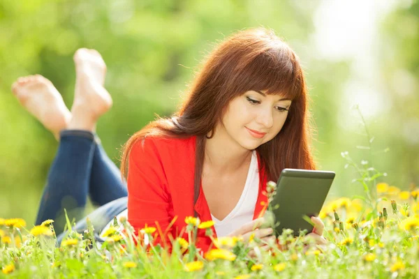 Šťastná žena s tablet v parku — Stock fotografie