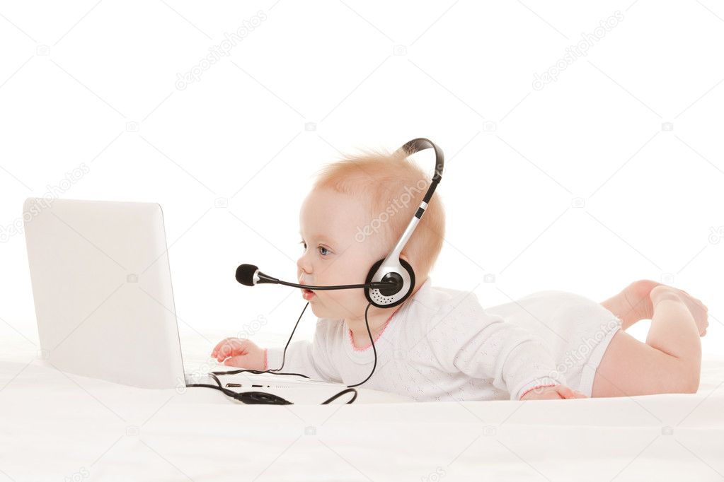 Cute baby-operator with laptop on the white bed