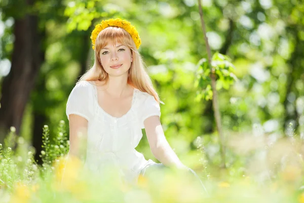 Carino riposo donna nel parco con denti di leone — Foto Stock