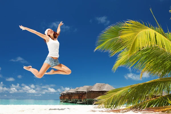 幸せな若い女性がビーチでジャンプ — ストック写真