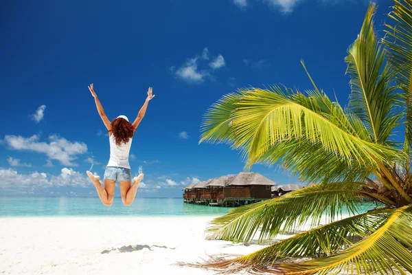 Feliz jovem mulher pulando na praia tropical — Fotografia de Stock