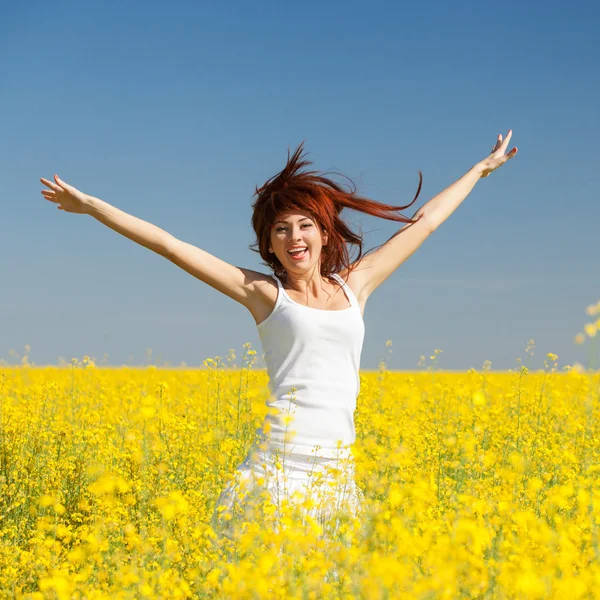 Mujer linda en el campo con flores —  Fotos de Stock