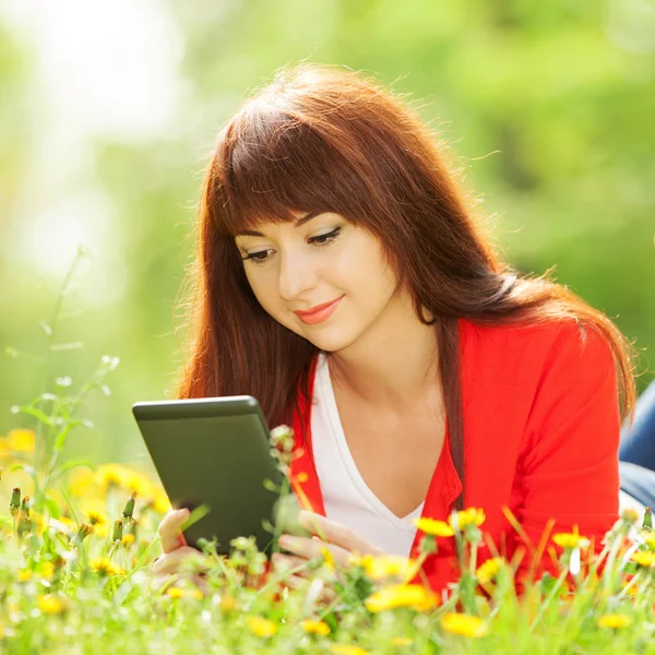 Gelukkige vrouw met tablet in het park — Stockfoto