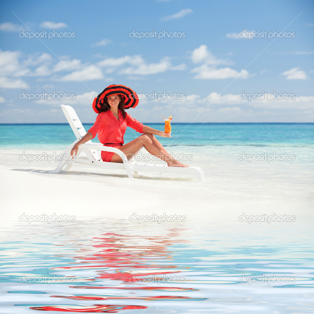 Fashion woman drinking cocktail on the beach