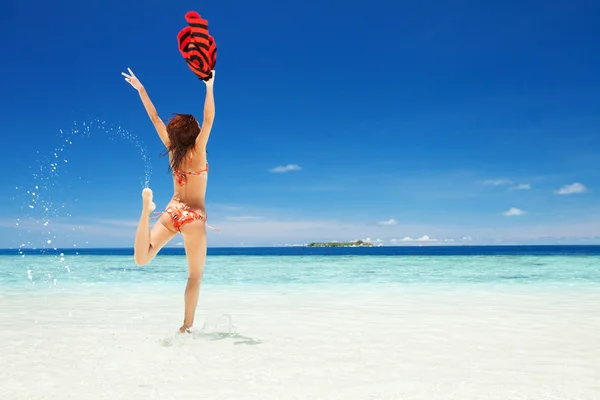幸せな若い女性がビーチでジャンプ — ストック写真