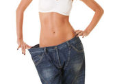 žena ukazuje její úbytek na váze tím, že nosí staré džíny, izolovaných na