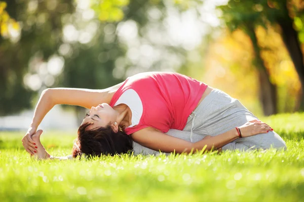 Krásná žena dělá jógu cvičení v parku — Stock fotografie