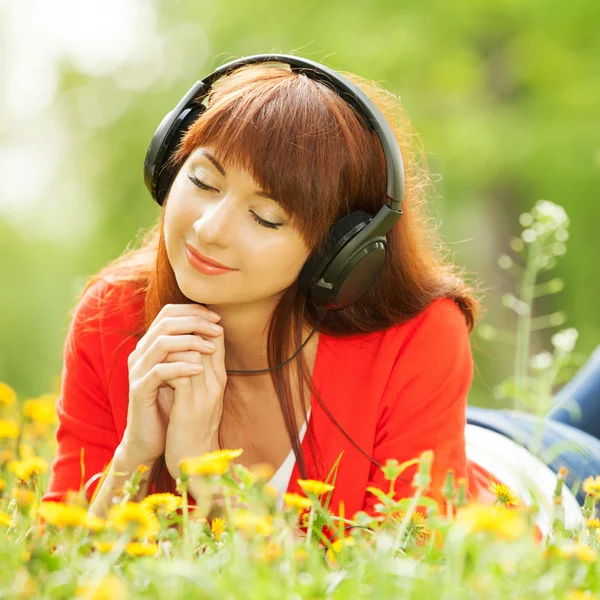 Donna felice con cuffie relax nel parco — Foto Stock