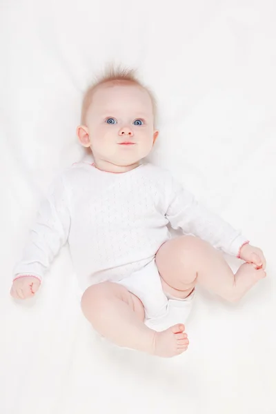 Carino bambino con bellissimi occhi blu sdraiato nel letto bianco — Foto Stock