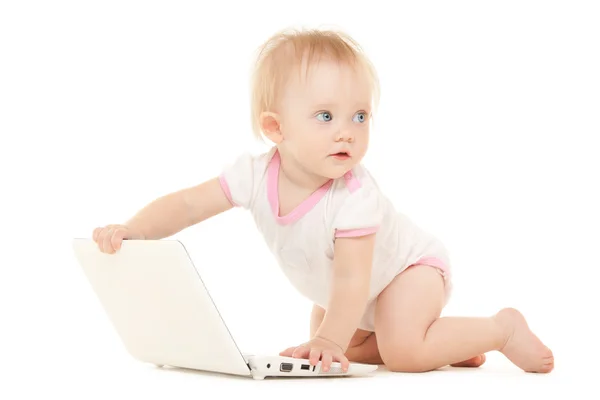 Cute baby with laptop on the white bed — Stock Photo, Image