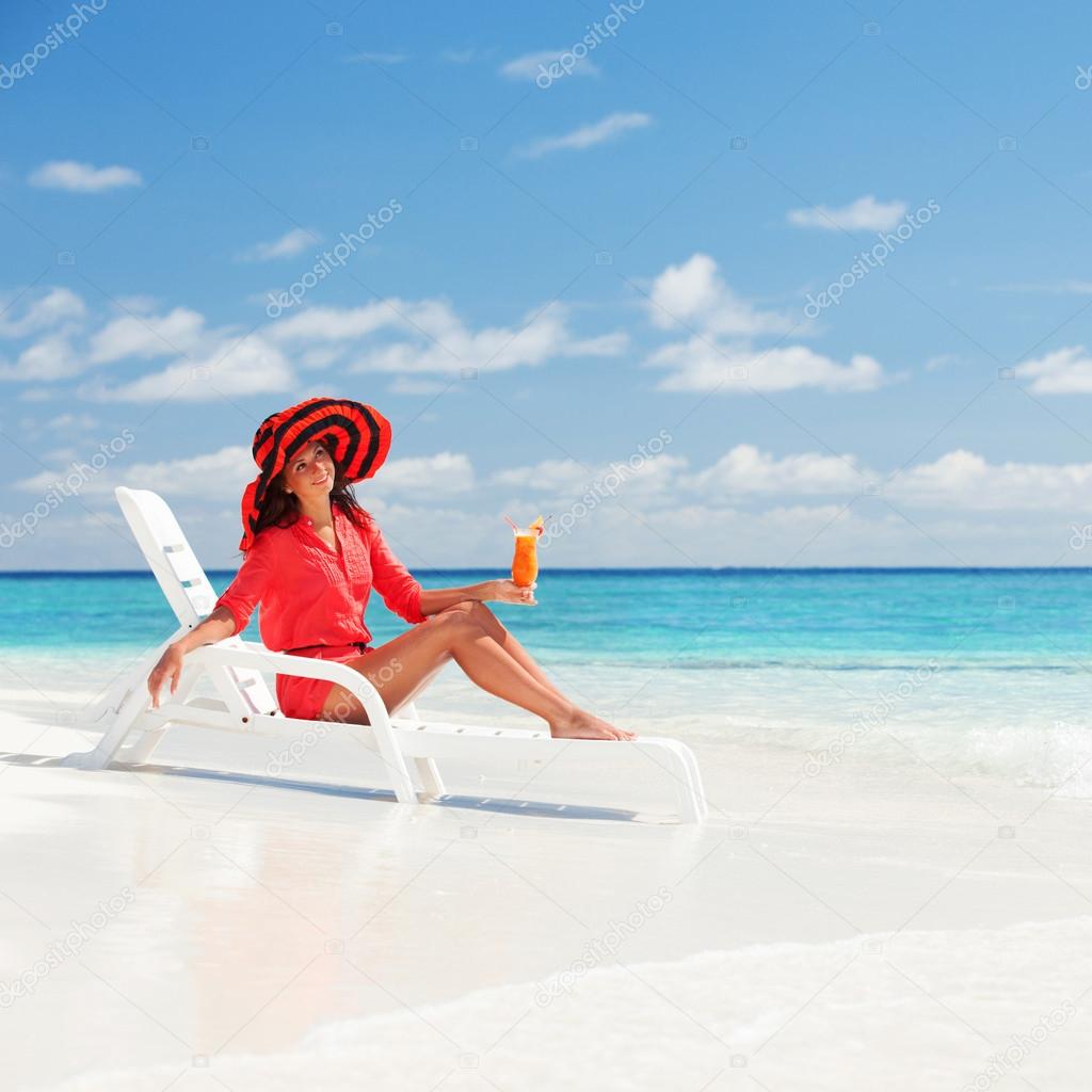 Fashion woman drinking cocktail on the beach