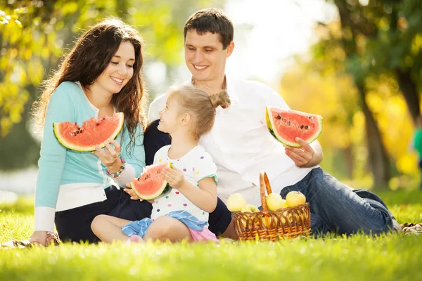 Happy family having a picnic in the autumn garden — Stock Photo, Image