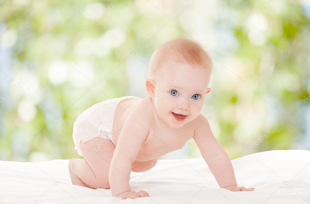 Cute baby with beautiful blue eyes on the white bed