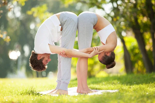 Casal Yoga, homem e mulher fazendo exercícios de ioga no parque — Fotografia de Stock