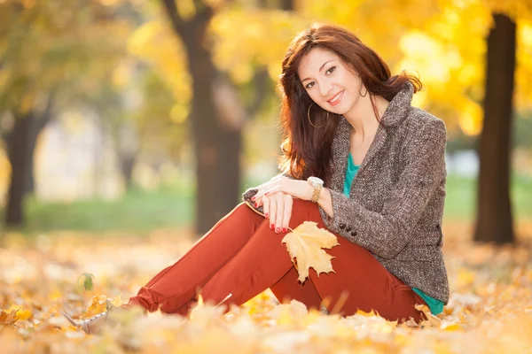 Giovane bella donna rilassante nel parco autunnale — Foto Stock