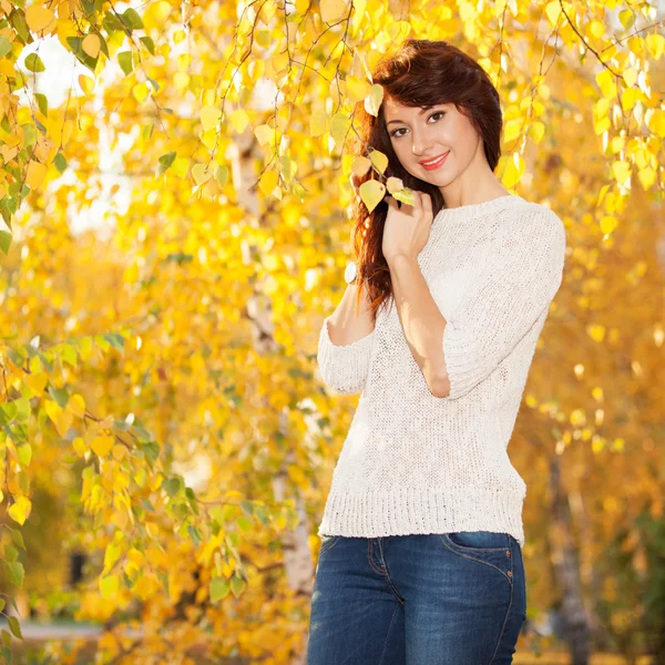 Junge hübsche Frau spaziert durch den Herbstpark — Stockfoto