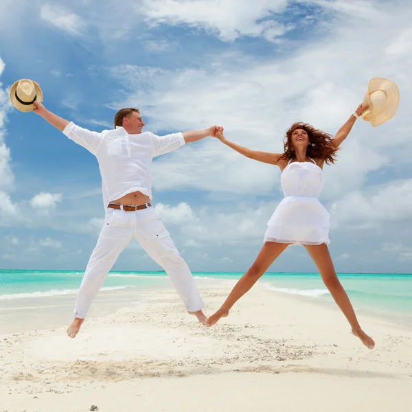 Feliz casal pulando na praia tropical — Fotografia de Stock