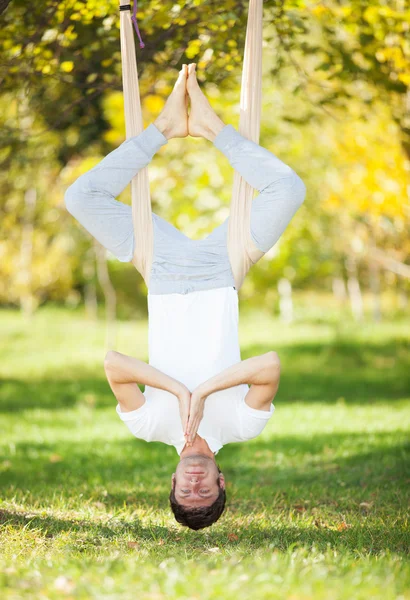 Anti-gravity Yoga, man doing yoga exercises in the park — Stock Photo, Image