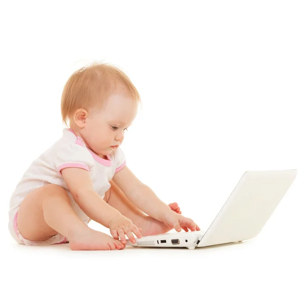 Niedliches Baby mit Laptop auf dem weißen Bett — Stockfoto