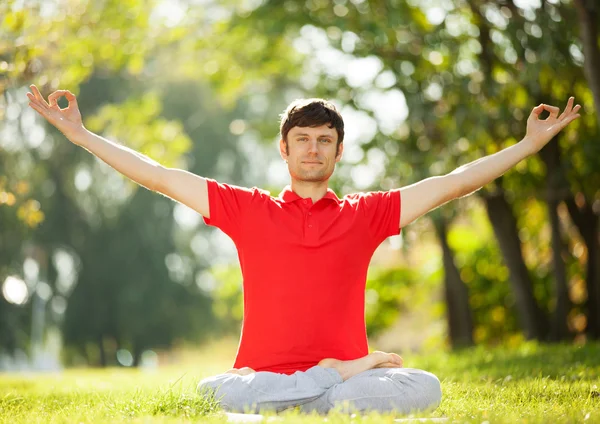 Adam parkta yoga egzersizleri yapıyor. — Stok fotoğraf