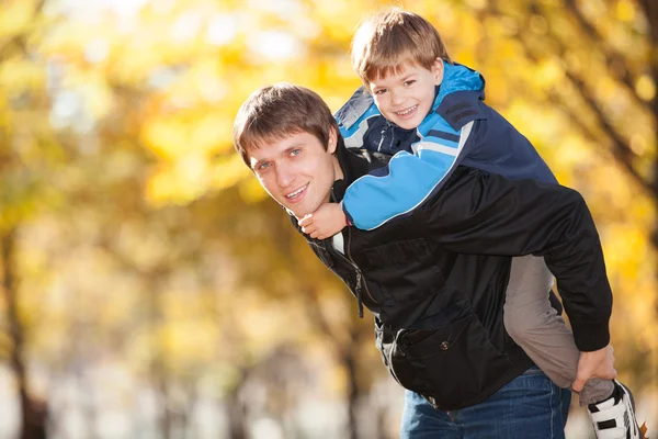 Buon padre e suo figlio nel parco autunnale — Foto Stock