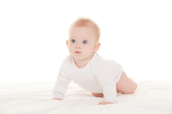 Bebê bonito com belos olhos azuis na cama branca — Fotografia de Stock