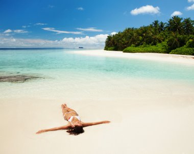 Cute woman relaxing on the tropical beach clipart