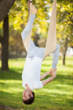 Anti-yerçekimi yoga, yoga egzersizleri parkta yapan erkek