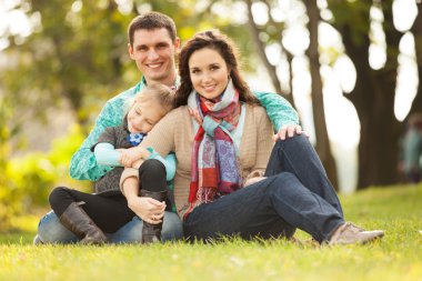 Mutlu anne, baba ve kız parkta