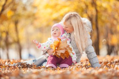 Anne ve kızı sonbahar parkında.