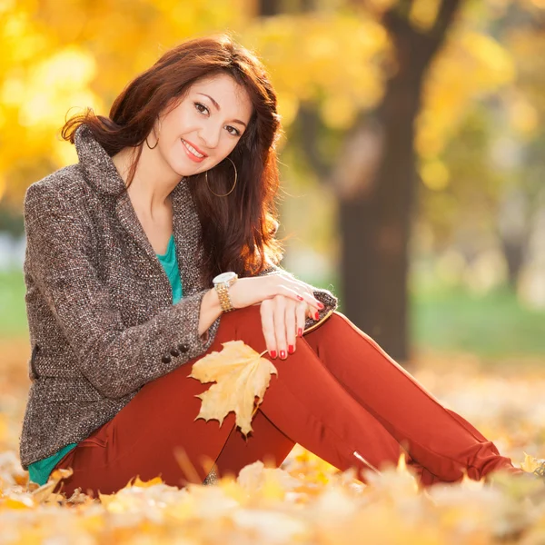 Giovane bella donna rilassante nel parco autunnale — Foto Stock