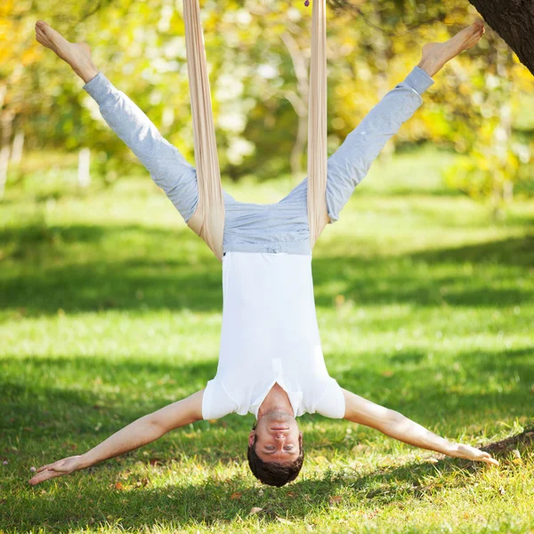 Anti-gravity Yoga, man doing yoga exercises in the park — Stock Photo, Image