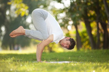Adam parkta yoga egzersizleri yapıyor.